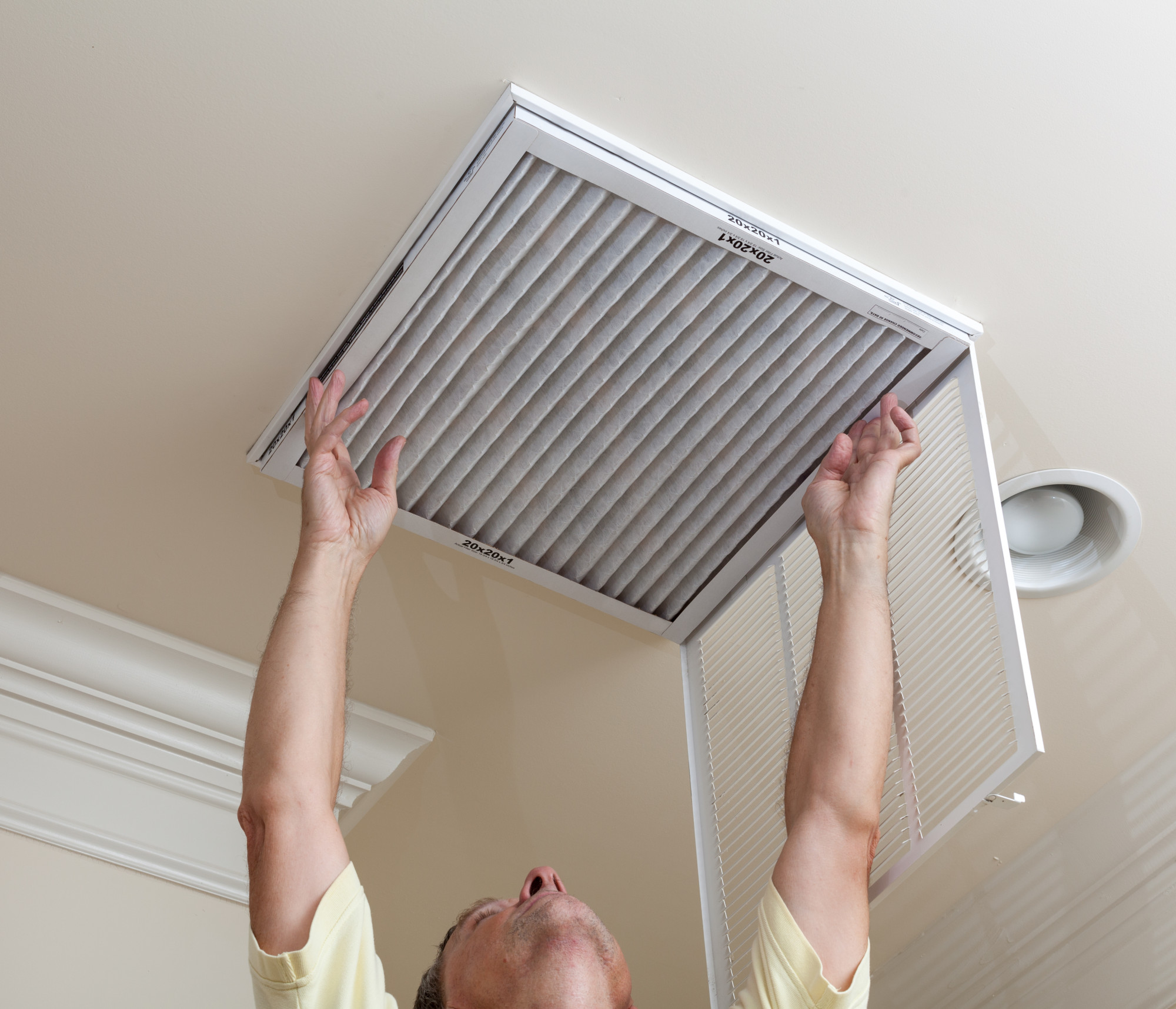 man replacing HVAC filter